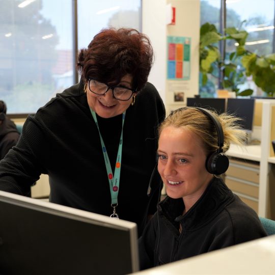  Person helping another person at a computer